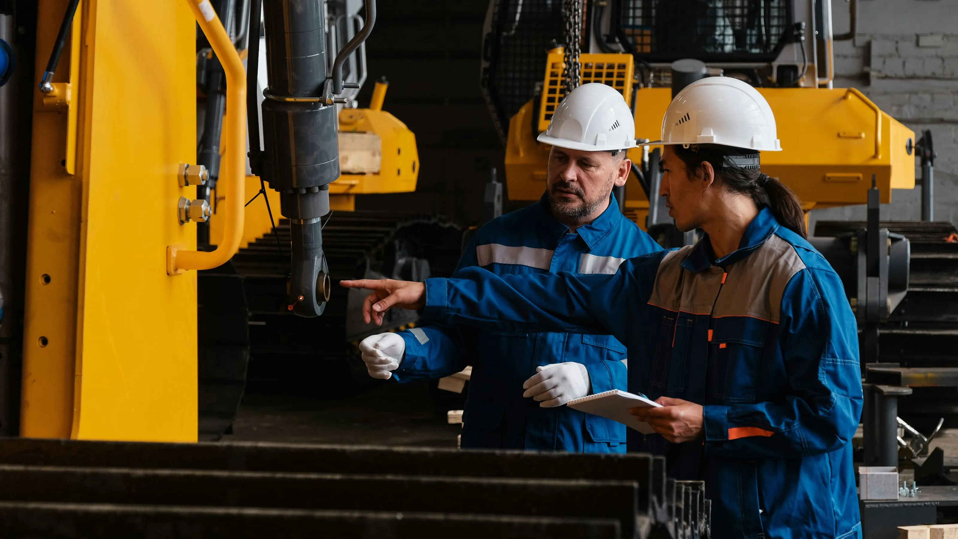 Trades operators reviewing industrial equipment in a workshop.
